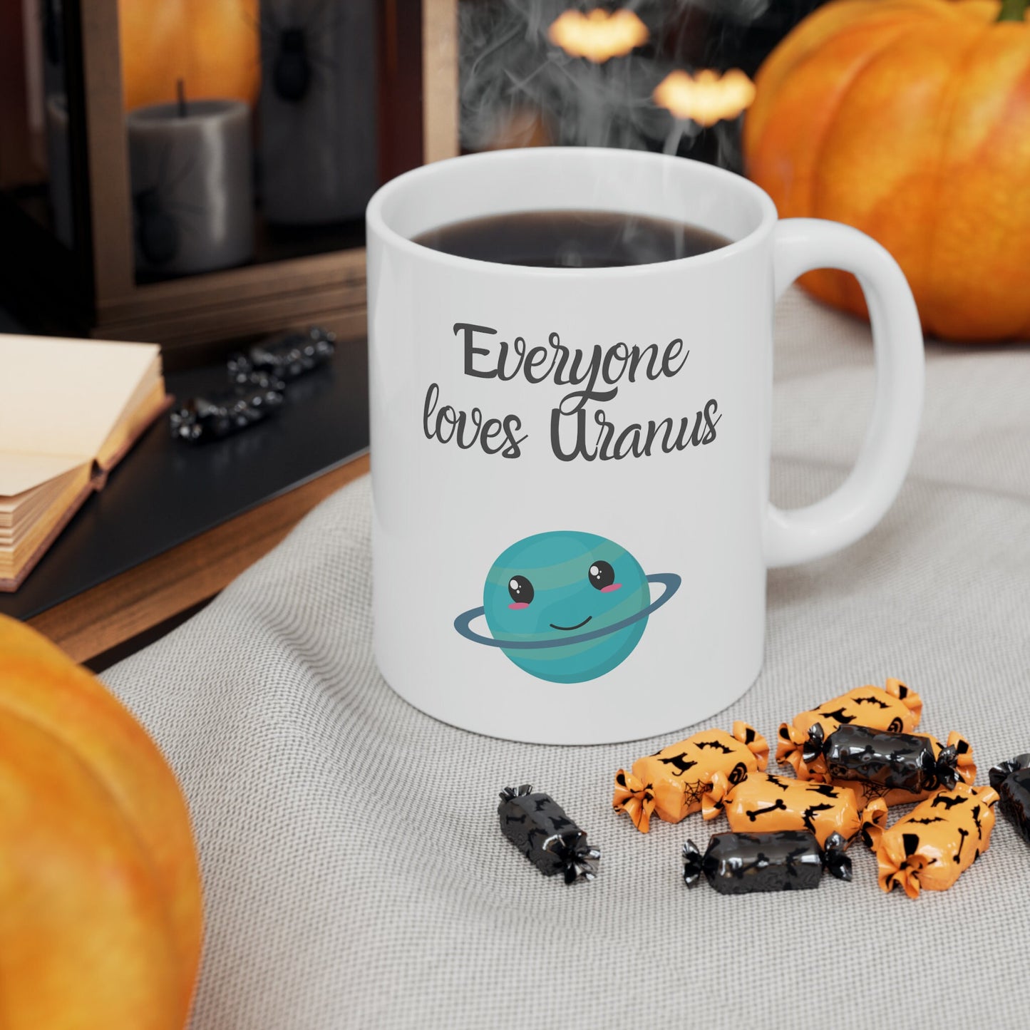White Ceramic Mug with words in Script style black font that say, Everyone Loves Uranus. Beneath you find a Cute graphic of the Planet Uranus with an adorable face.  Check out the shop for more items at www.scorpiontees.etsy.com