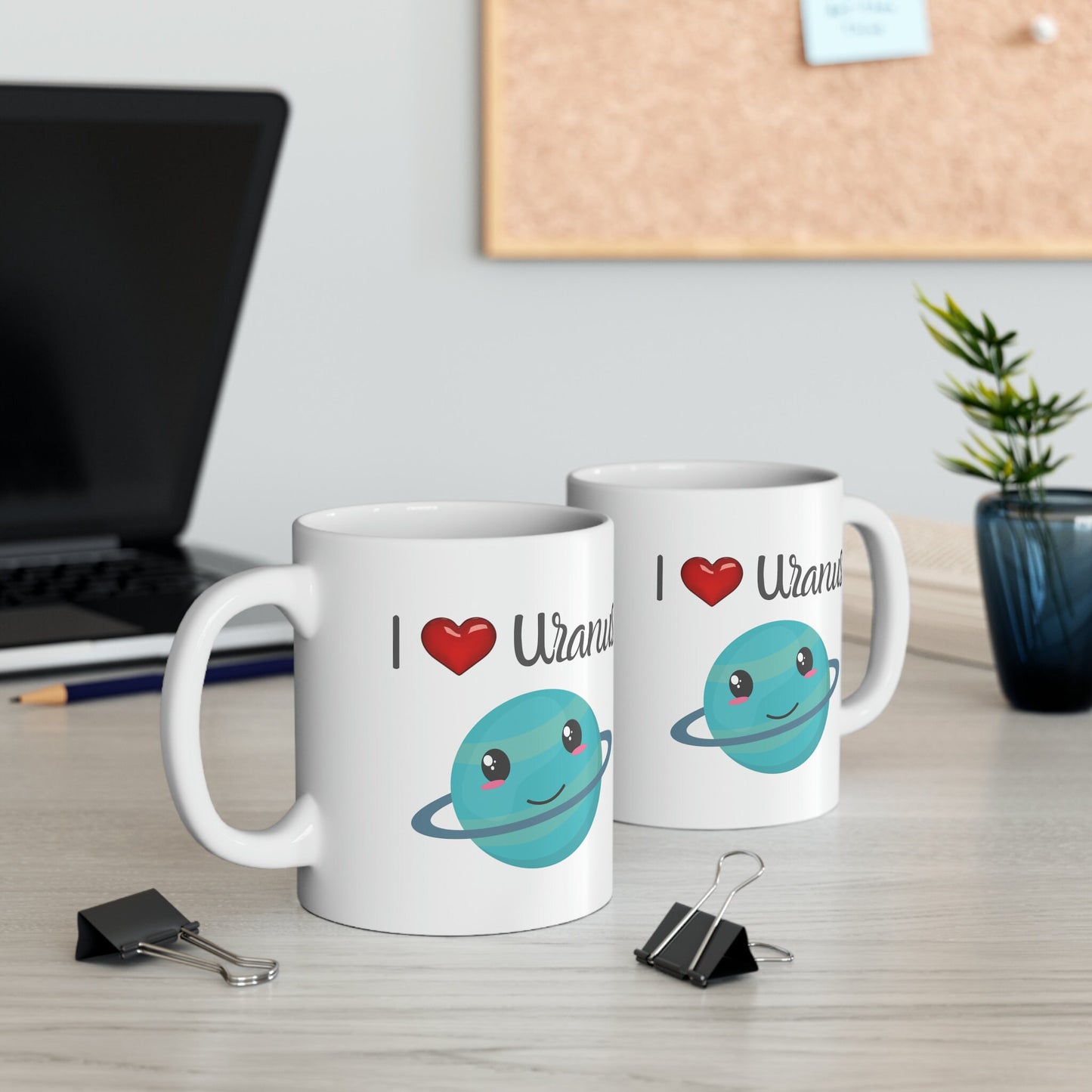 White Ceramic Mug with words in Script style black font that say, I Love Uranus.  Love as a red heart symbol.  Beneath you find a Cute graphic of the Planet Uranus with an adorable face.  Check out the shop for more items at www.scorpiontees.etsy.com