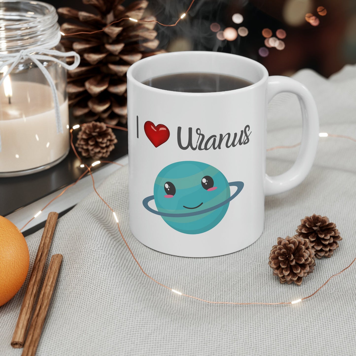 White Ceramic Mug with words in Script style black font that say, I Love Uranus.  Love as a red heart symbol.  Beneath you find a Cute graphic of the Planet Uranus with an adorable face.  Check out the shop for more items at www.scorpiontees.etsy.com