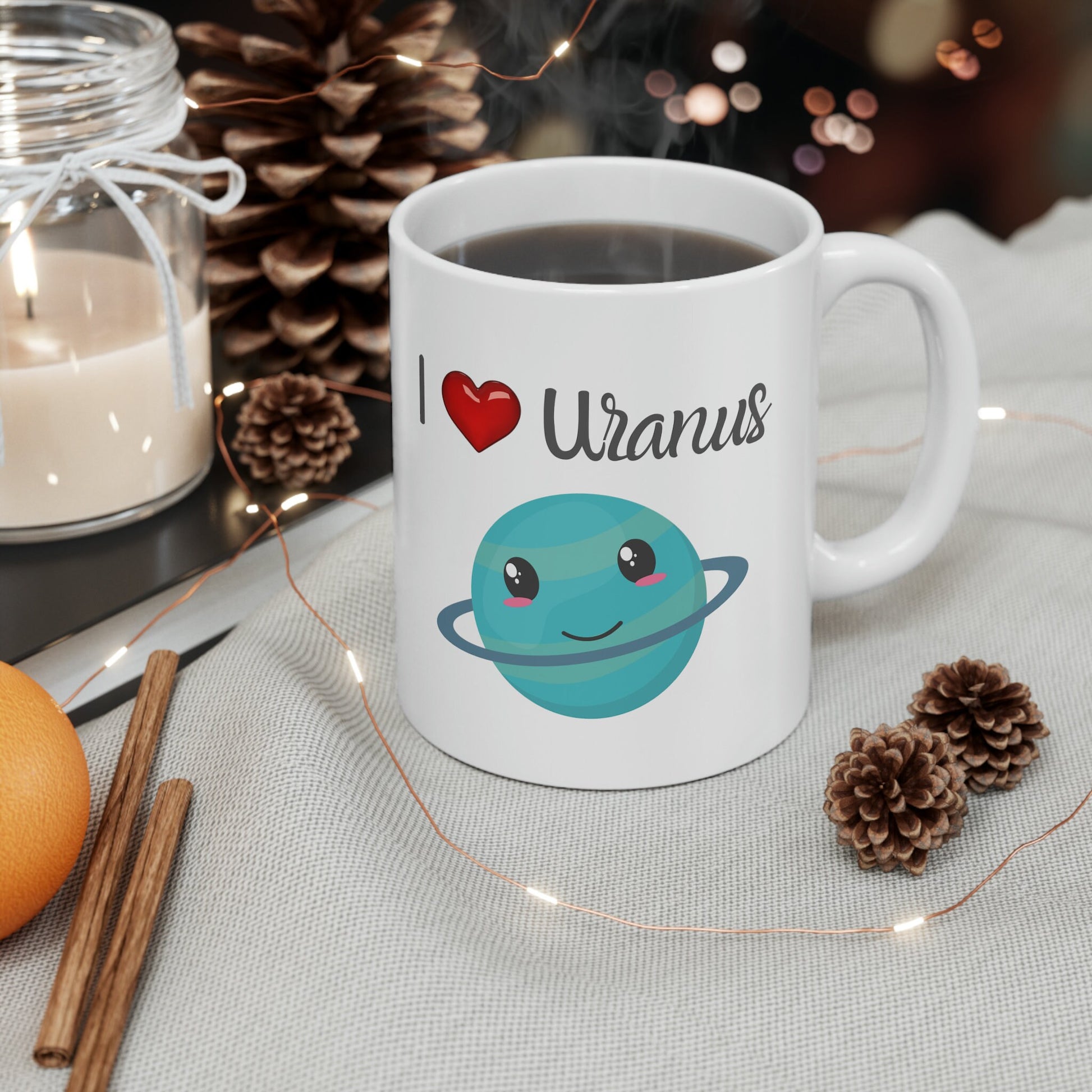 White Ceramic Mug with words in Script style black font that say, I Love Uranus.  Love as a red heart symbol.  Beneath you find a Cute graphic of the Planet Uranus with an adorable face.  Check out the shop for more items at www.scorpiontees.etsy.com