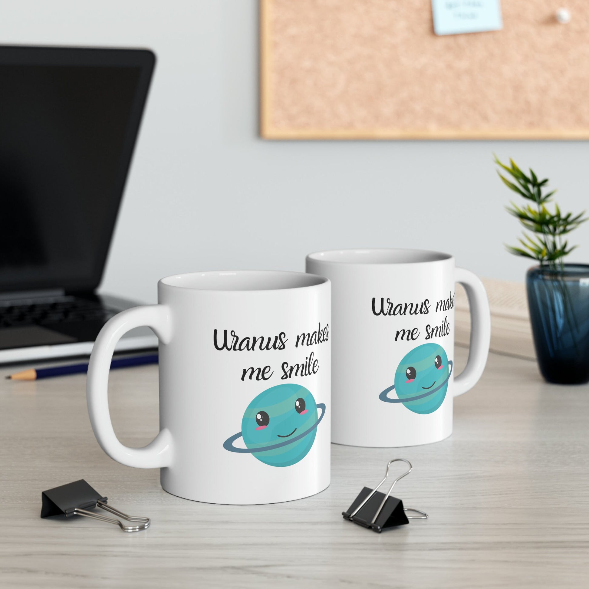 White Ceramic Mug with words in Script style black font that say, Uranus makes me smile. Beneath you find a Cute graphic of the Planet Uranus with an adorable face.  Check out the shop for more items at www.scorpiontees.etsy.com