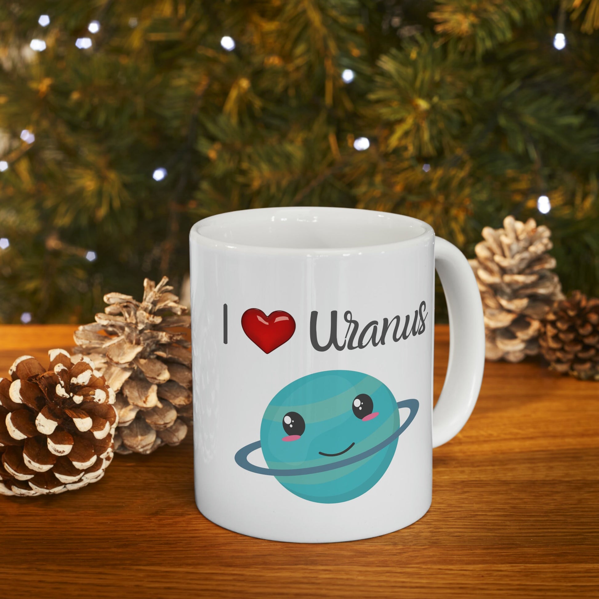 White Ceramic Mug with words in Script style black font that say, I Love Uranus.  Love as a red heart symbol.  Beneath you find a Cute graphic of the Planet Uranus with an adorable face.  Check out the shop for more items at www.scorpiontees.etsy.com