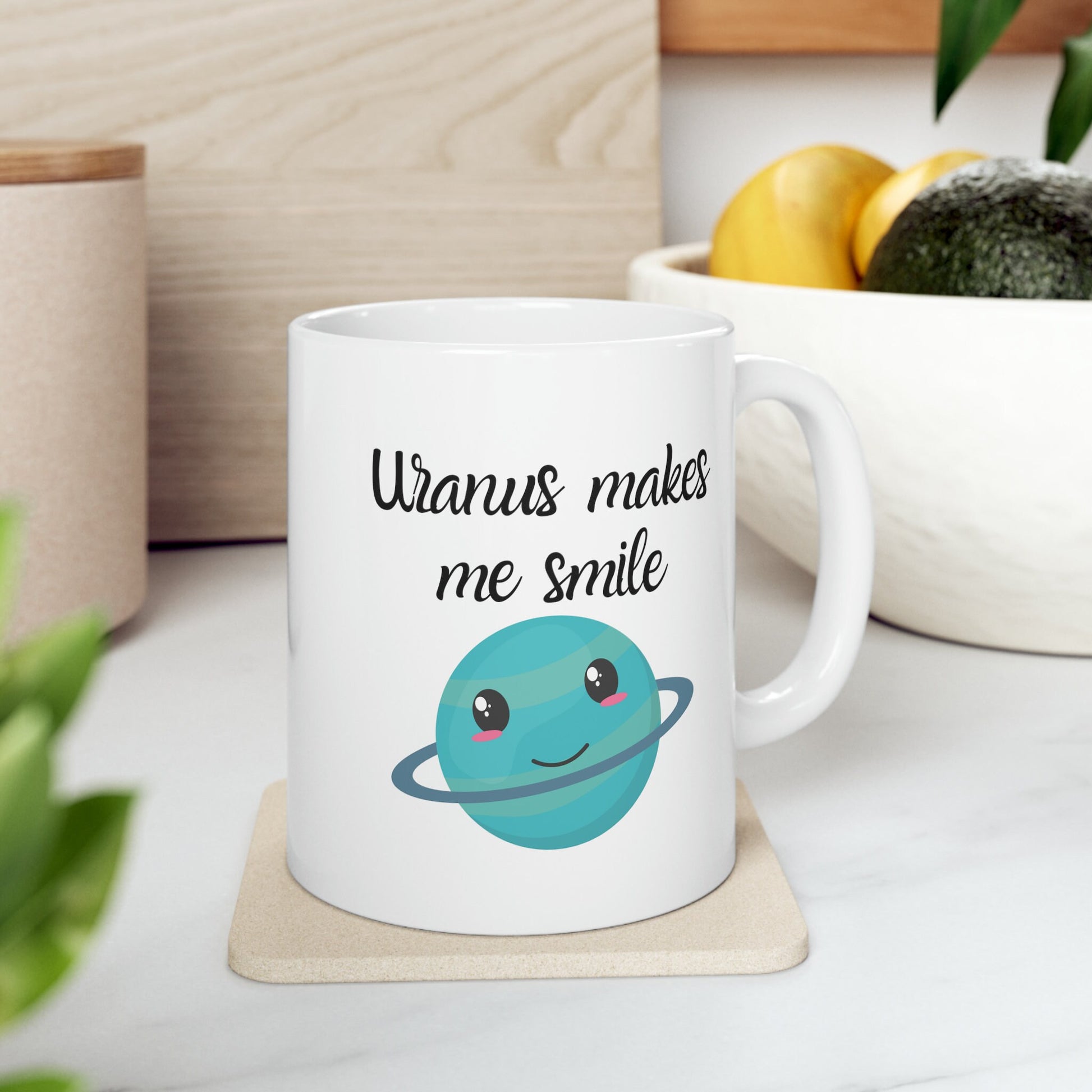 White Ceramic Mug with words in Script style black font that say, Uranus makes me smile. Beneath you find a Cute graphic of the Planet Uranus with an adorable face.  Check out the shop for more items at www.scorpiontees.etsy.com