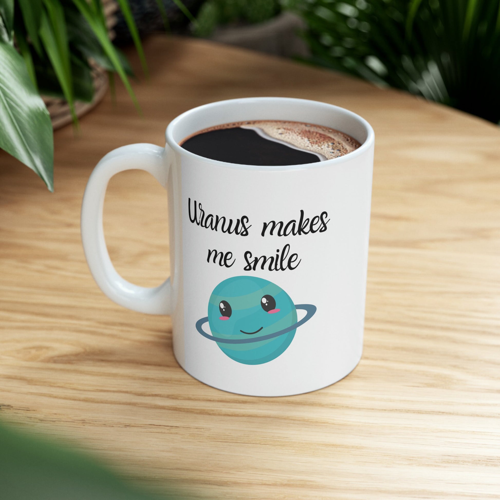 White Ceramic Mug with words in Script style black font that say, Uranus makes me smile. Beneath you find a Cute graphic of the Planet Uranus with an adorable face.  Check out the shop for more items at www.scorpiontees.etsy.com