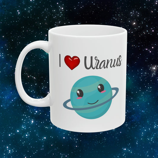 White Ceramic Mug with words in Script style black font that say, I Love Uranus.  Love as a red heart symbol.  Beneath you find a Cute graphic of the Planet Uranus with an adorable face.  Check out the shop for more items at www.scorpiontees.etsy.com