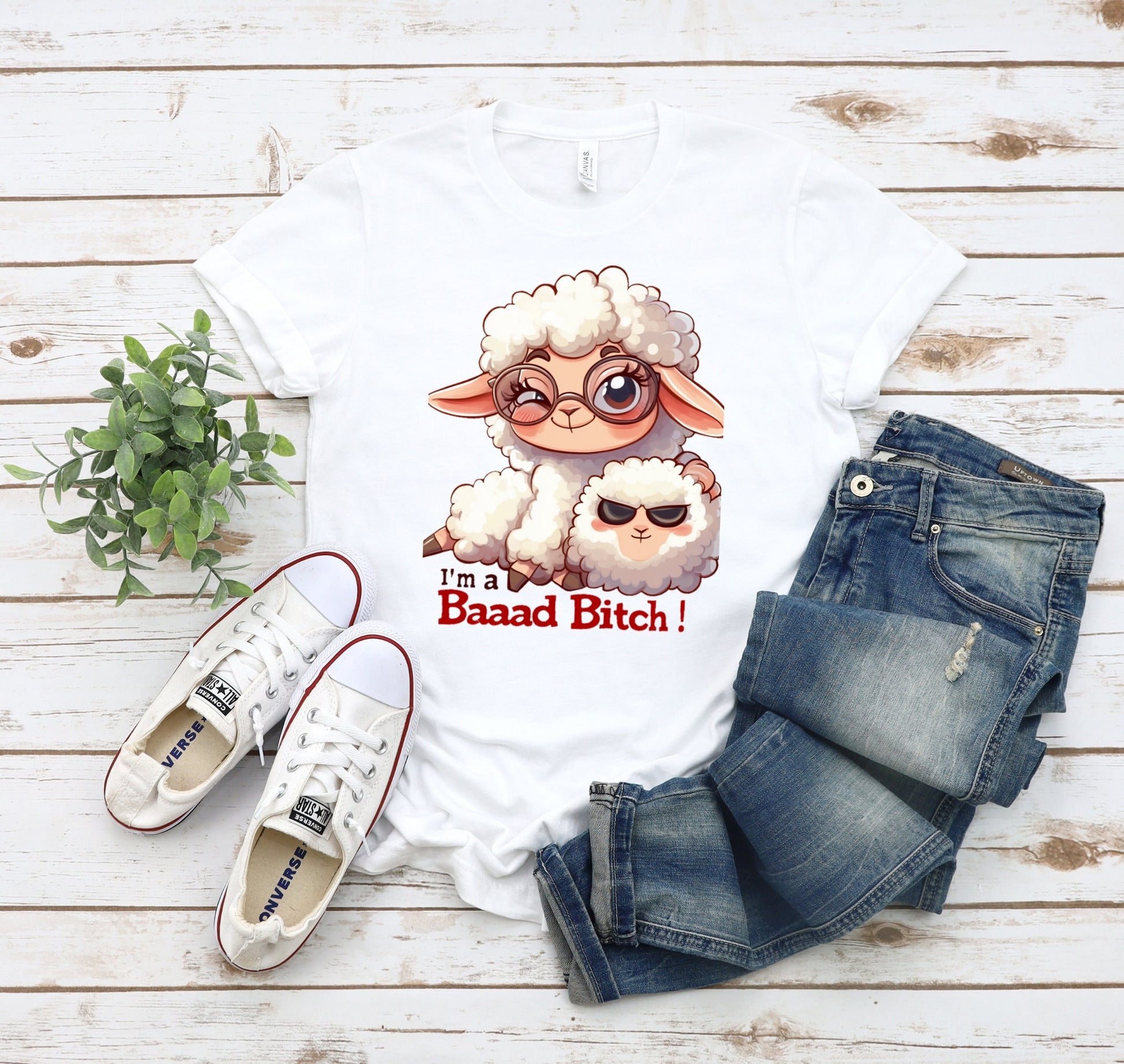 Pink T Shirt with a cute sheep wearing glasses and the words Im a baaad bitch in black and Red Letters.  The Sheep is holding a smaller sheep with black eyes that look like sunglasses. www.scorpiontees.etsy.com