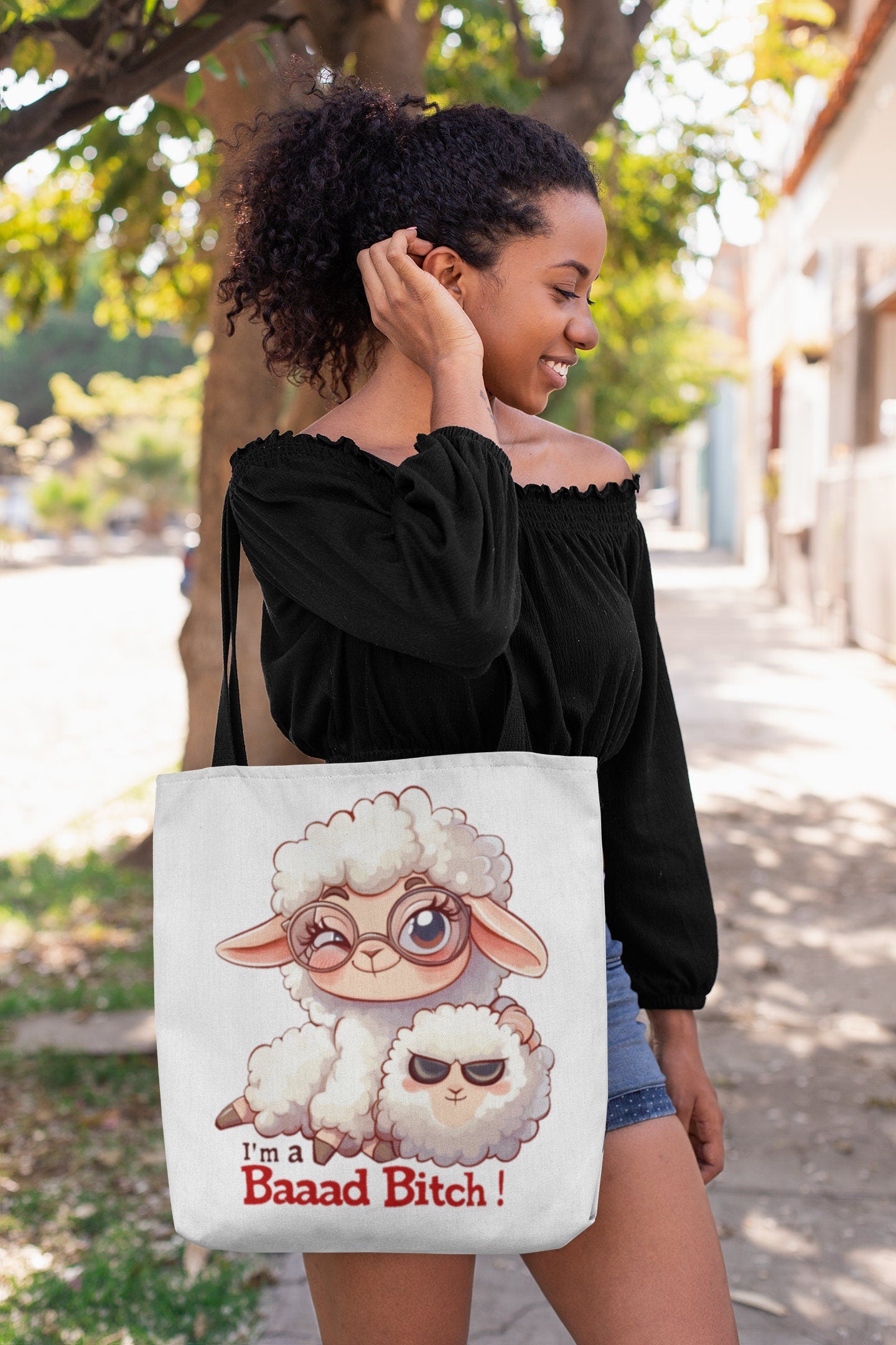 White Tote Bag with Black over the shoulder arm Handle featuring a sheep saying Im a Bad Bitch.  The word bad is written Baaad as if in sheep talk. The wording is in a black and red font.  www.scorpiontees.etsy.com