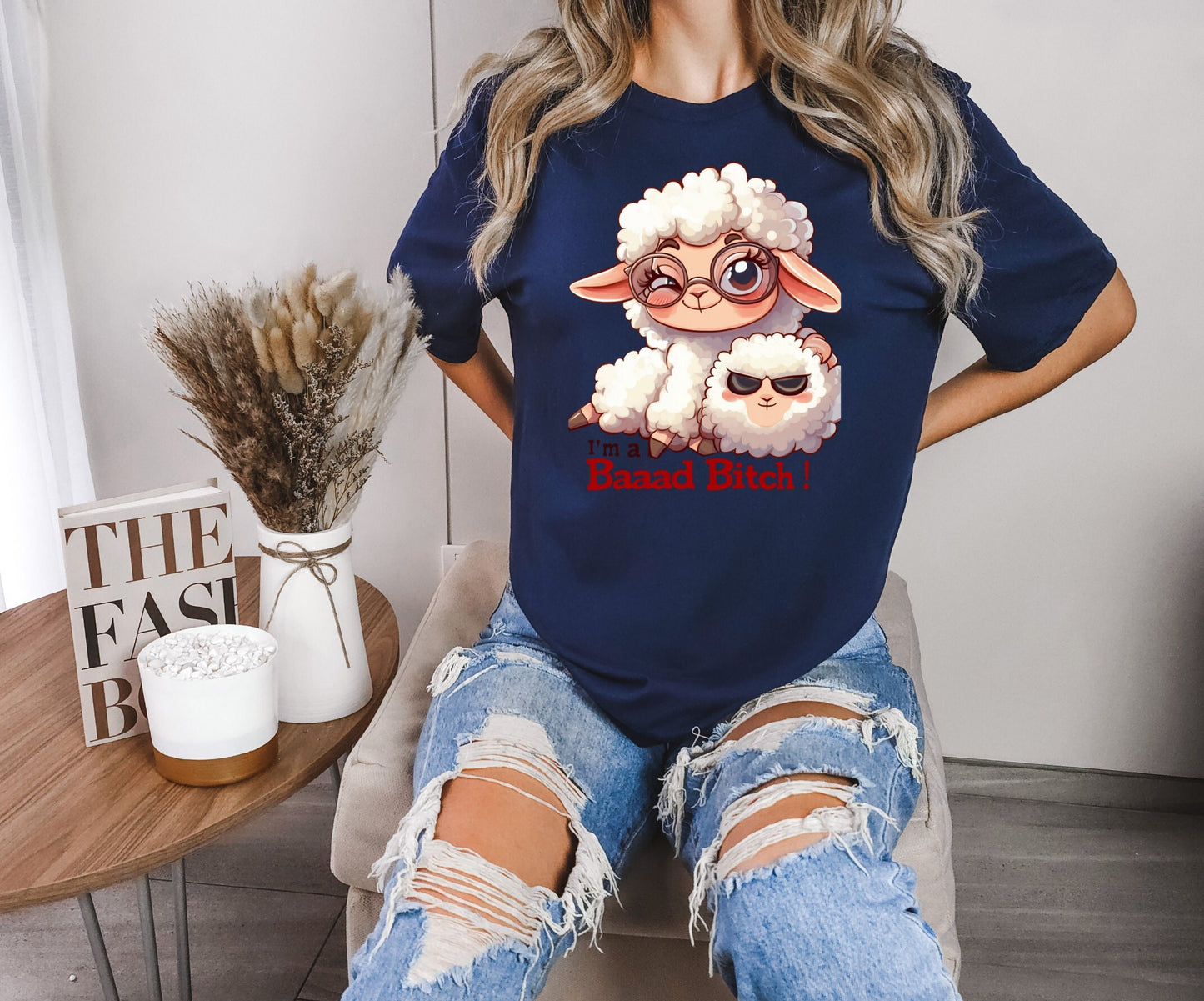 Pink T Shirt with a cute sheep wearing glasses and the words Im a baaad bitch in black and Red Letters.  The Sheep is holding a smaller sheep with black eyes that look like sunglasses. www.scorpiontees.etsy.com